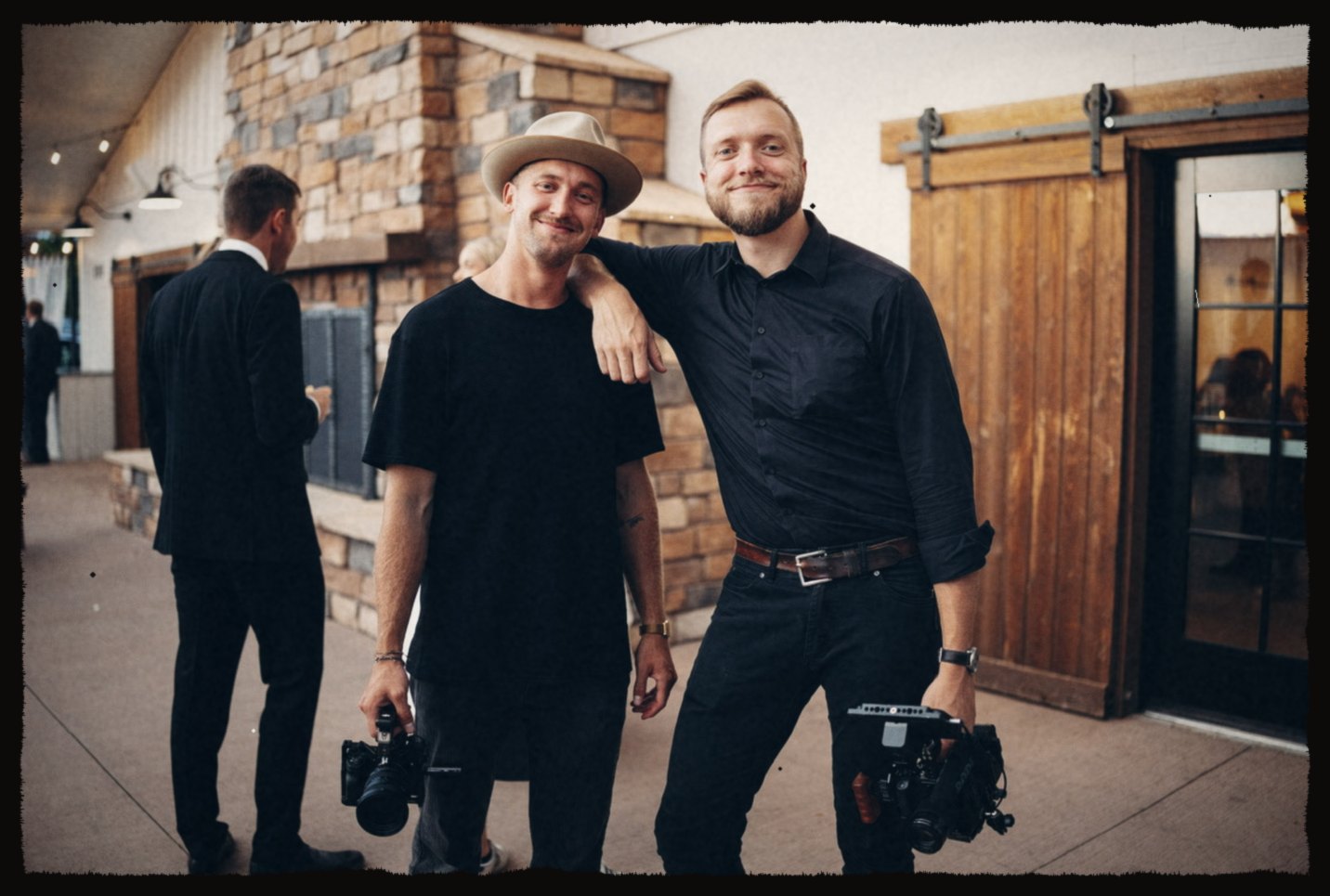 Two camera operators posing with their rigs at an event